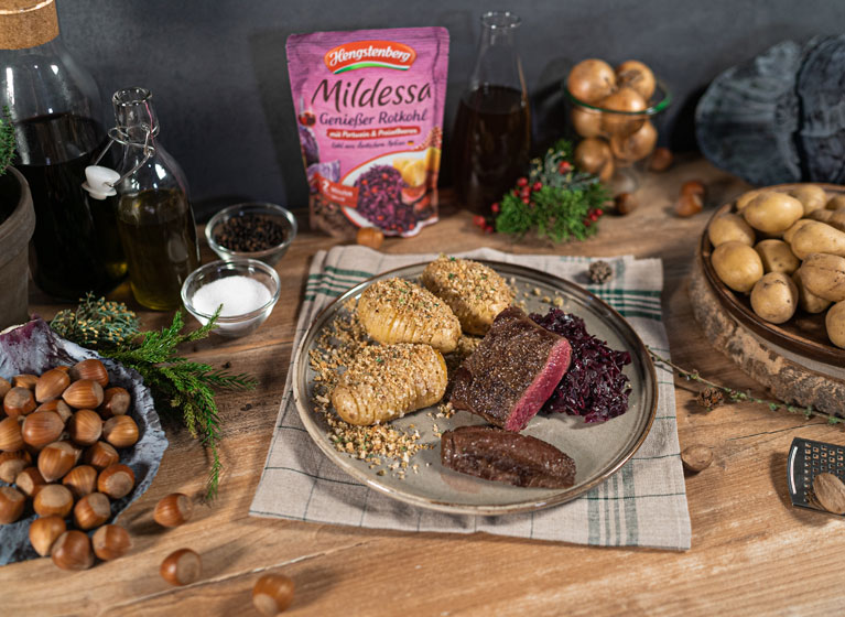 A plate with deer steaks and red cabbage.