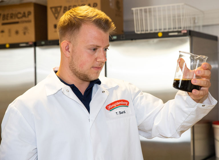 A employee proofing a bottle of vinegar.