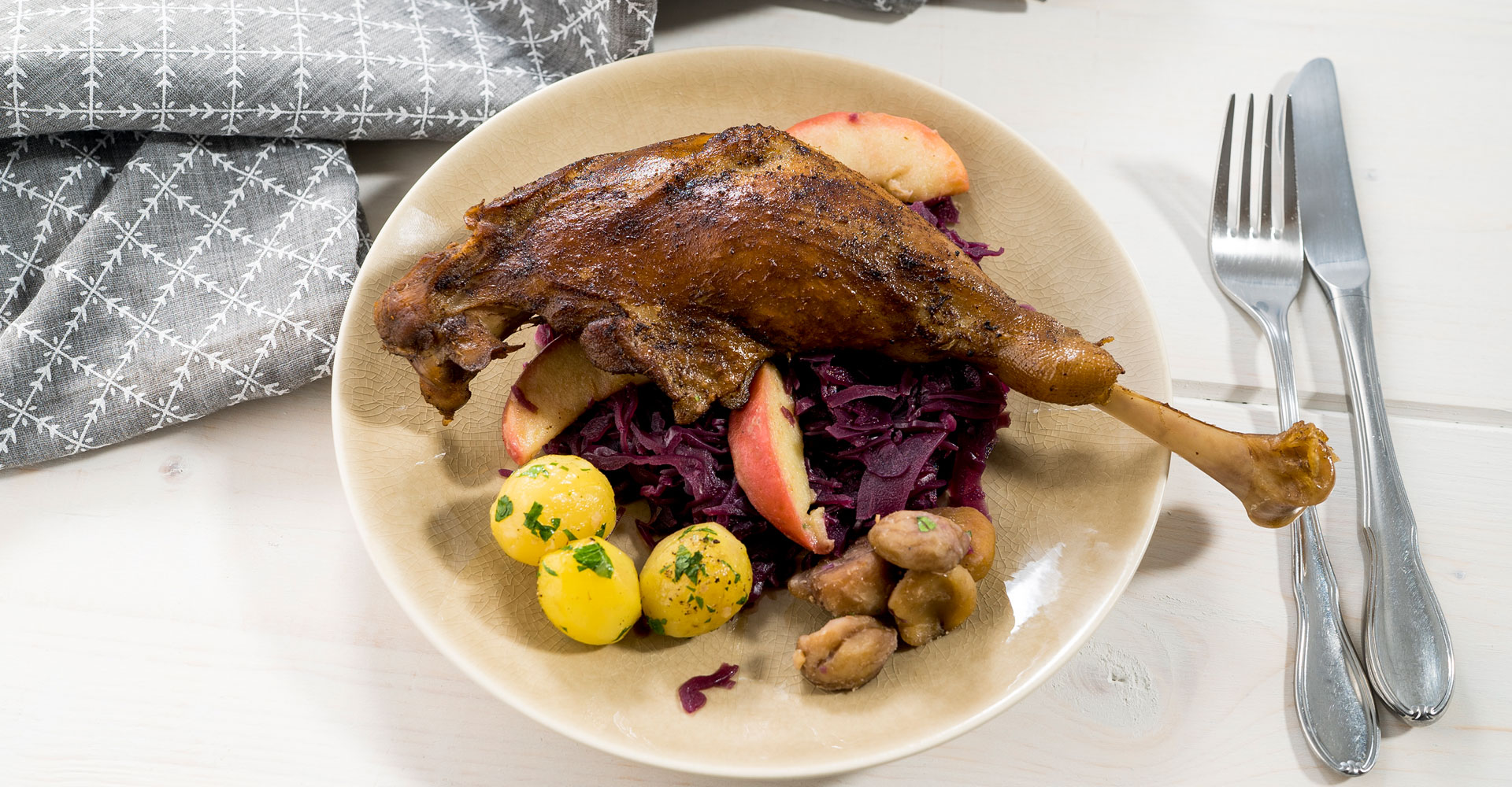 Goose legs with glazed apples, chestnut, red cabbage and potatoes