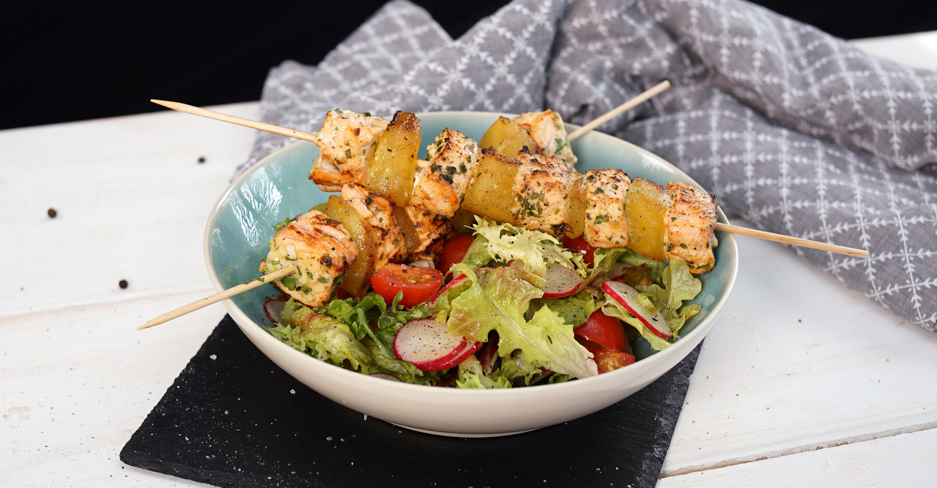 Grilled salmon skewers on tomato & radish salad