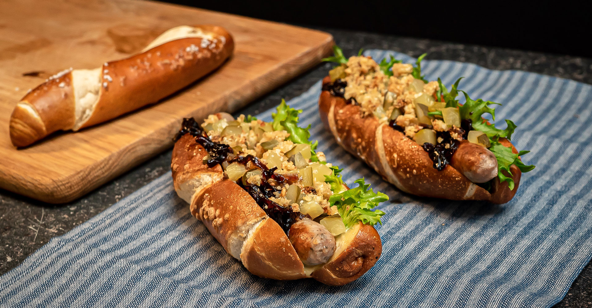 Pretzel hot dog with onion Jam and cauliflower & oat crumble