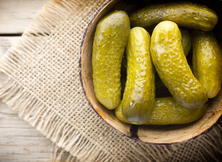 Some cucumbers in a wooden bowl.